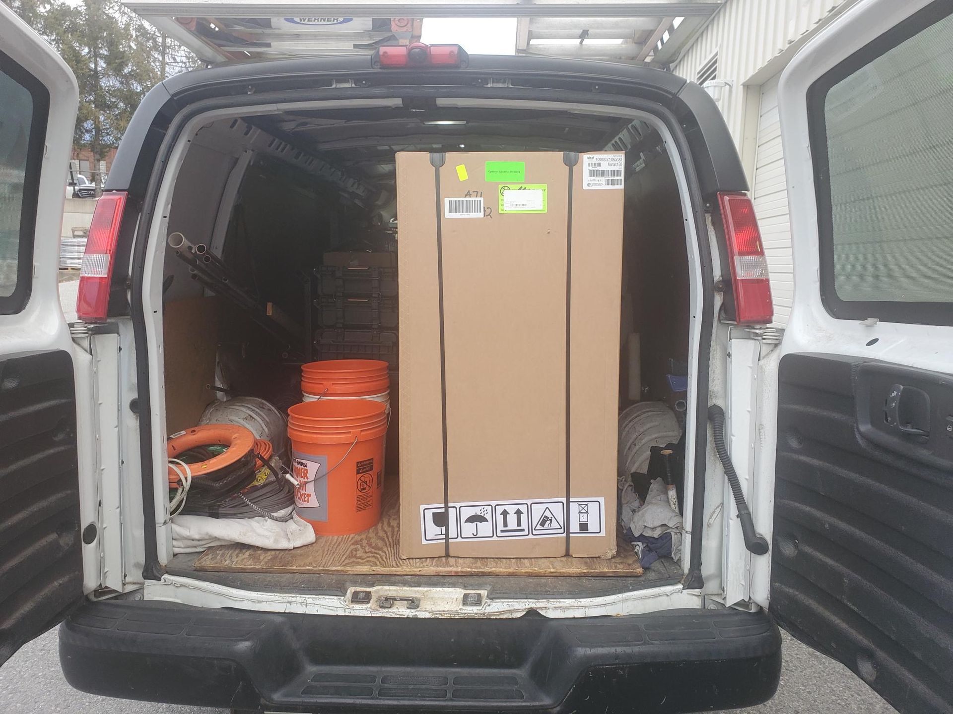 The back of a van is filled with boxes and buckets