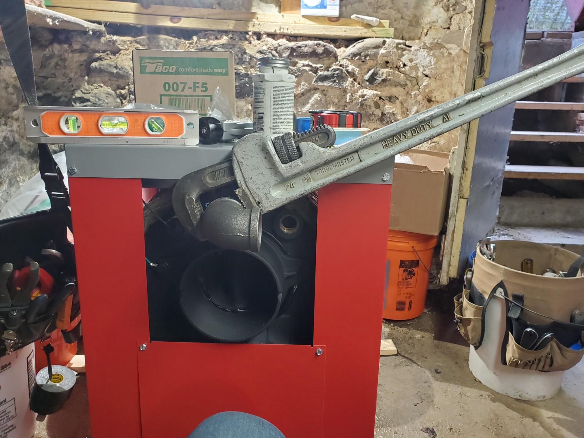 A wrench is sitting on top of a machine in a garage.