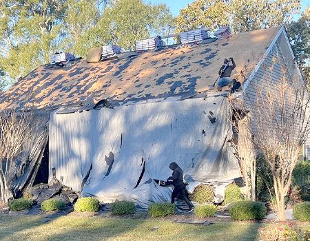 A man is working on the roof of a house.