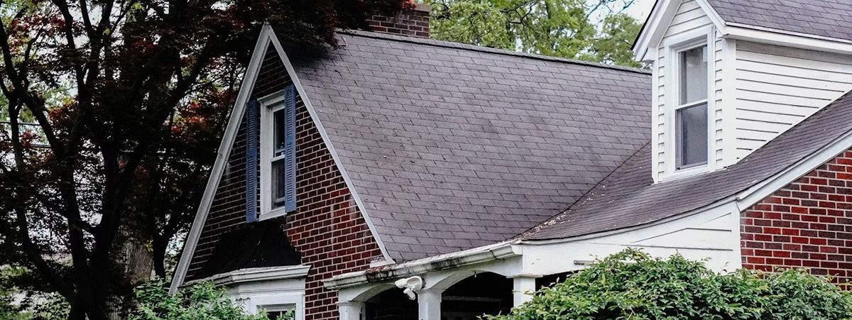 A white house with a silver metal roof