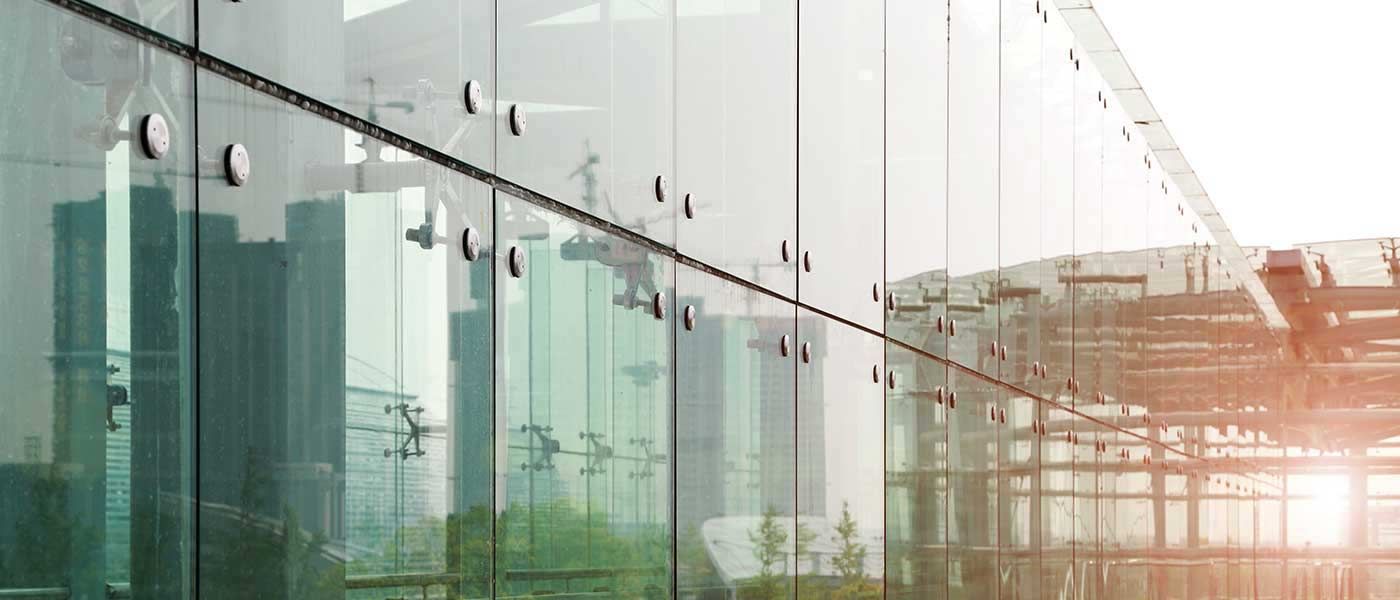 Un edificio con muchas ventanas y un reflejo de edificios en las ventanas.