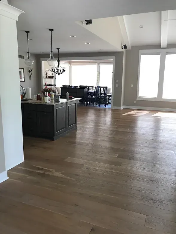 An artist 's impression of a modern kitchen with hardwood floors and stools.