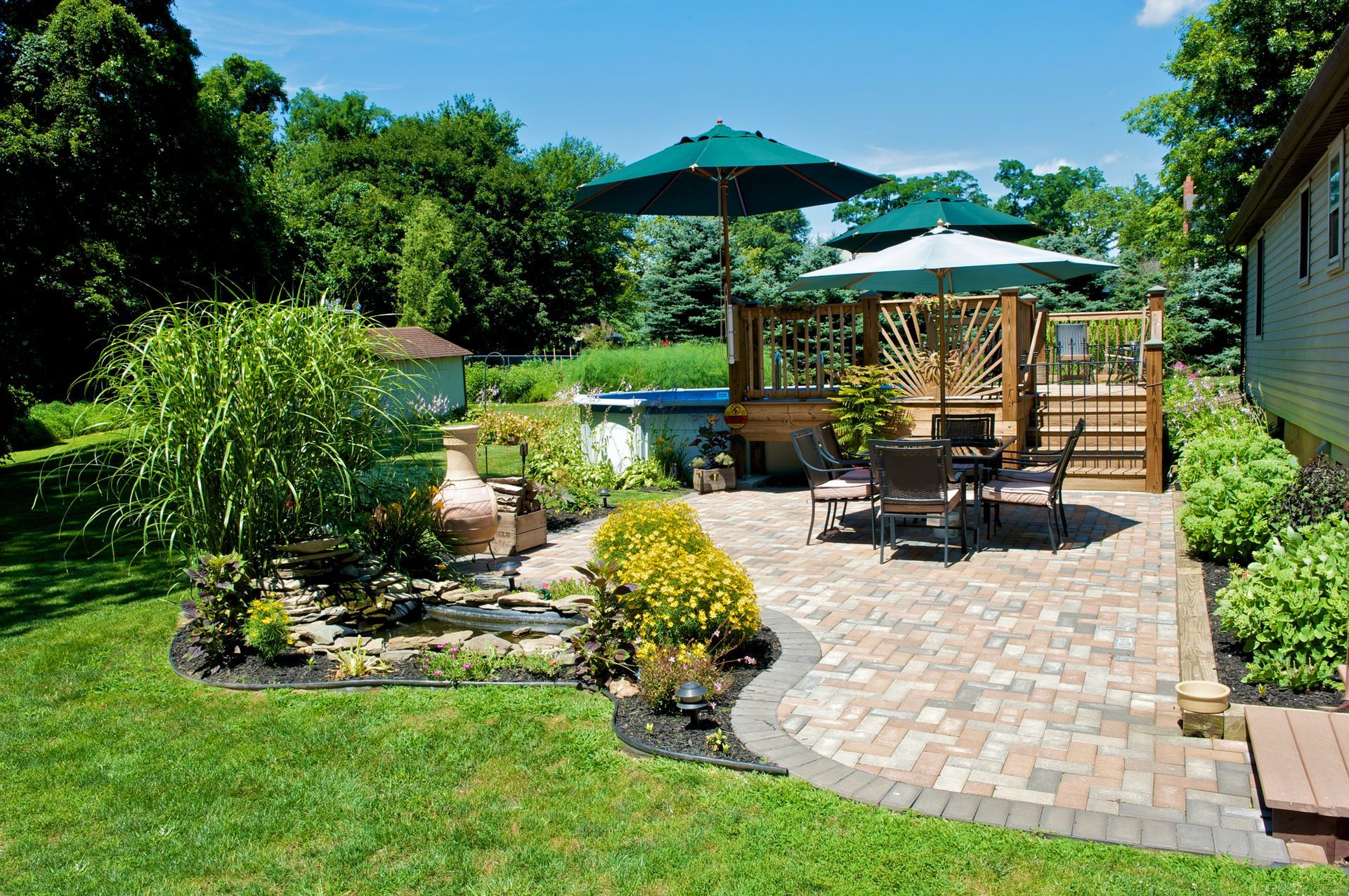 A backyard with a table and chairs and umbrellas