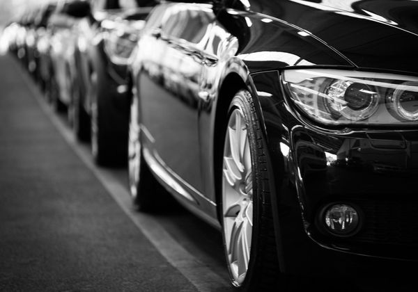 A black and white photo of a row of cars