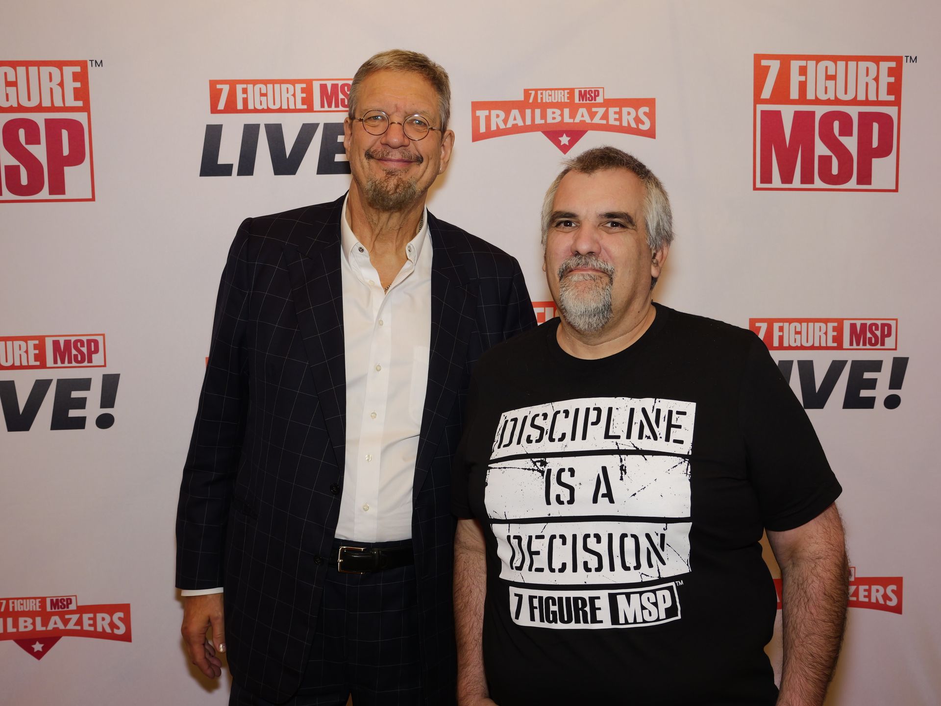 Two men standing in front of a wall that says discipline is a decision