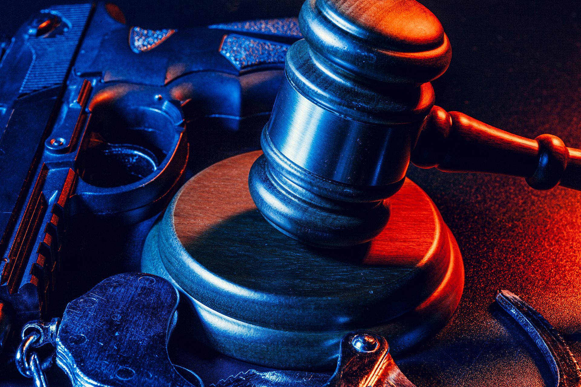Gun and judge's gavel on the table.