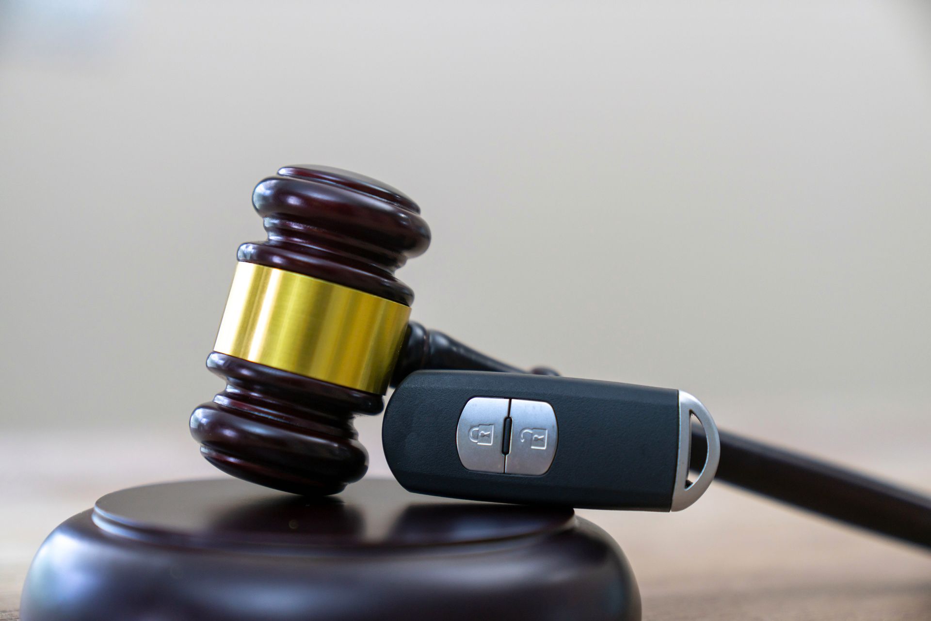 A wooden gavel with a car key fob on top.