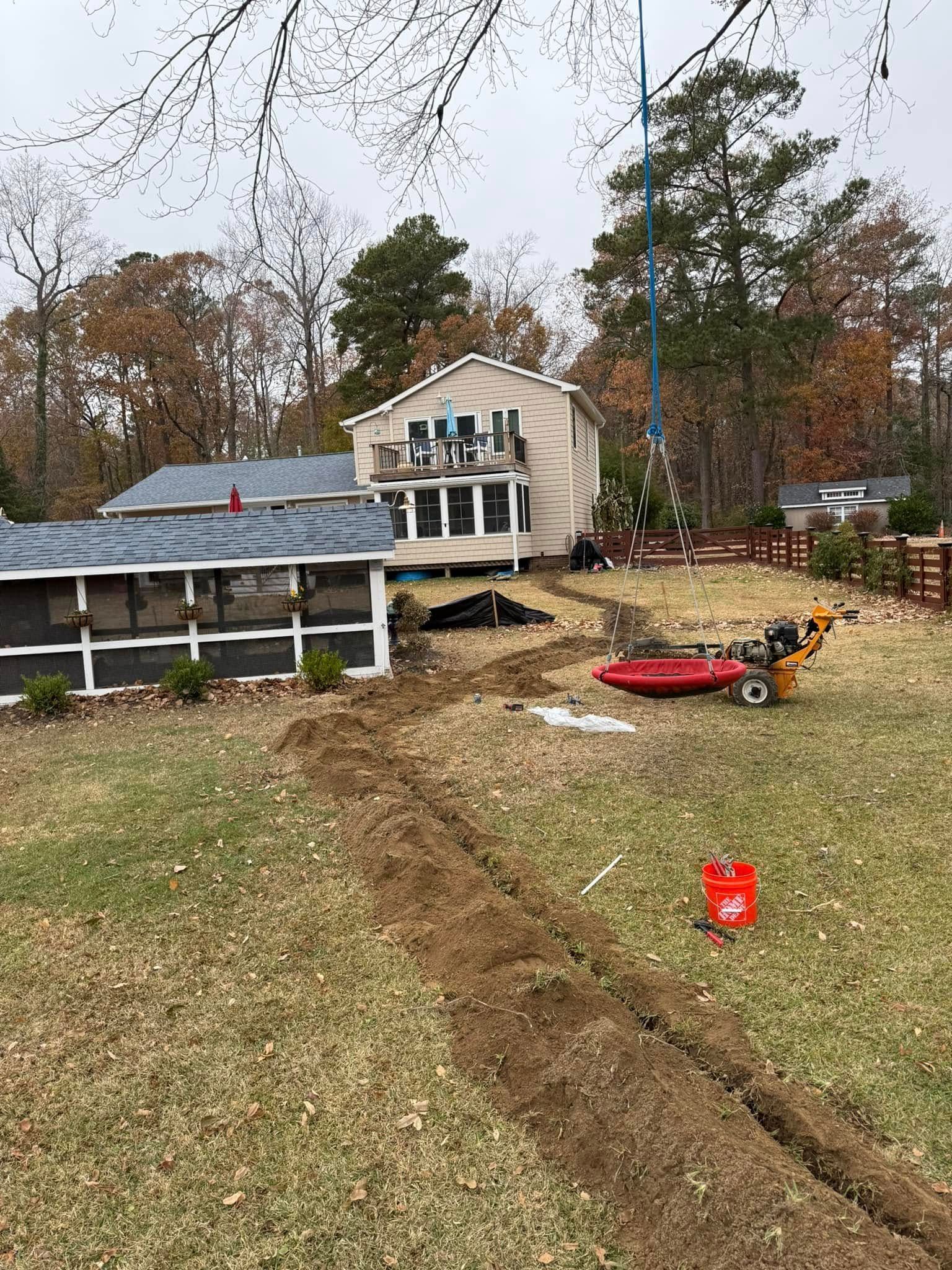 Underside of a sink showing plumbing: pipes, faucet lines, and drain in a dark cabinet.