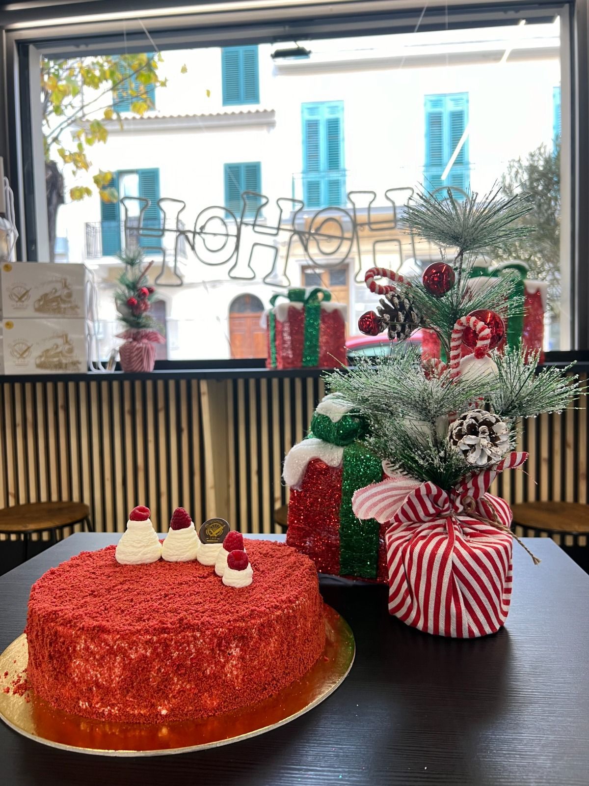 una torta rossa accanto a un albero di natale .