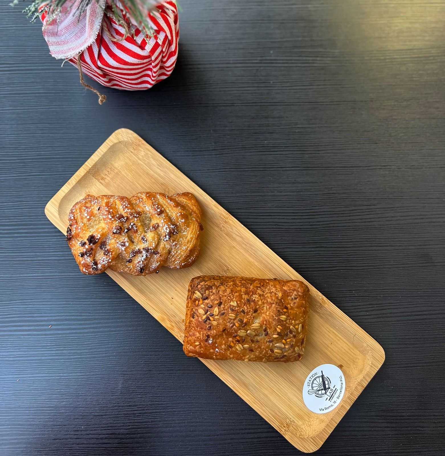 due brioche sono su un vassoio di legno su un tavolo .
