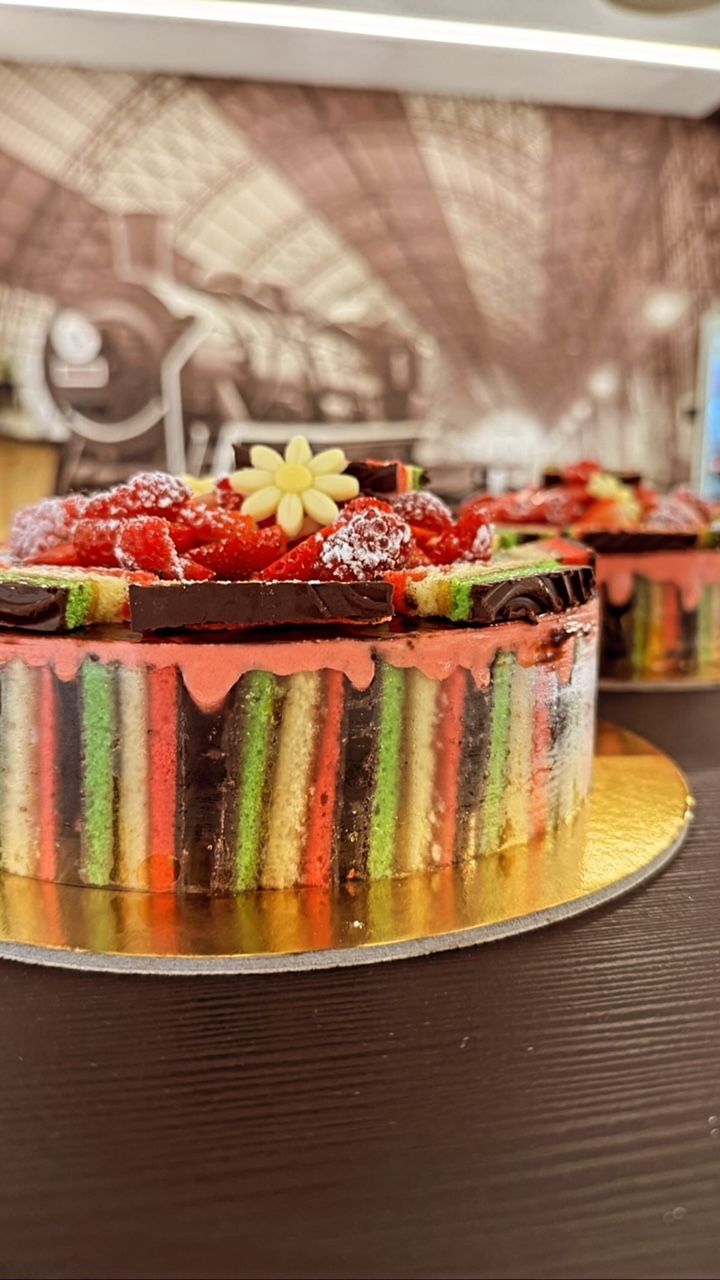 una torta arcobaleno con fragole e cioccolato