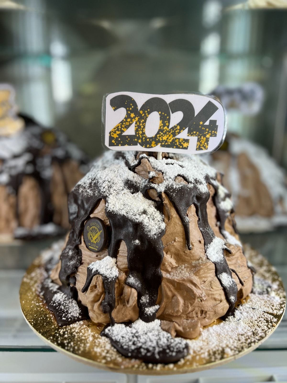 una torta al cioccolato con sopra un topper con il numero 2024 .