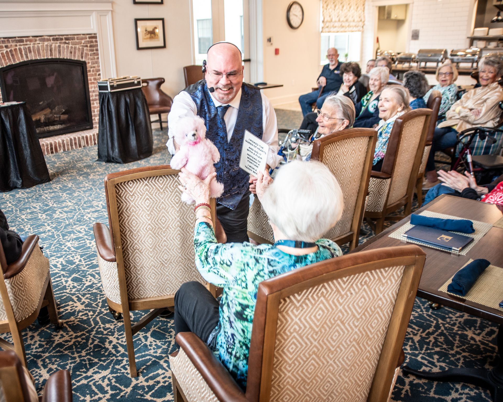 A man is holding a stuffed animal in front of a group of people