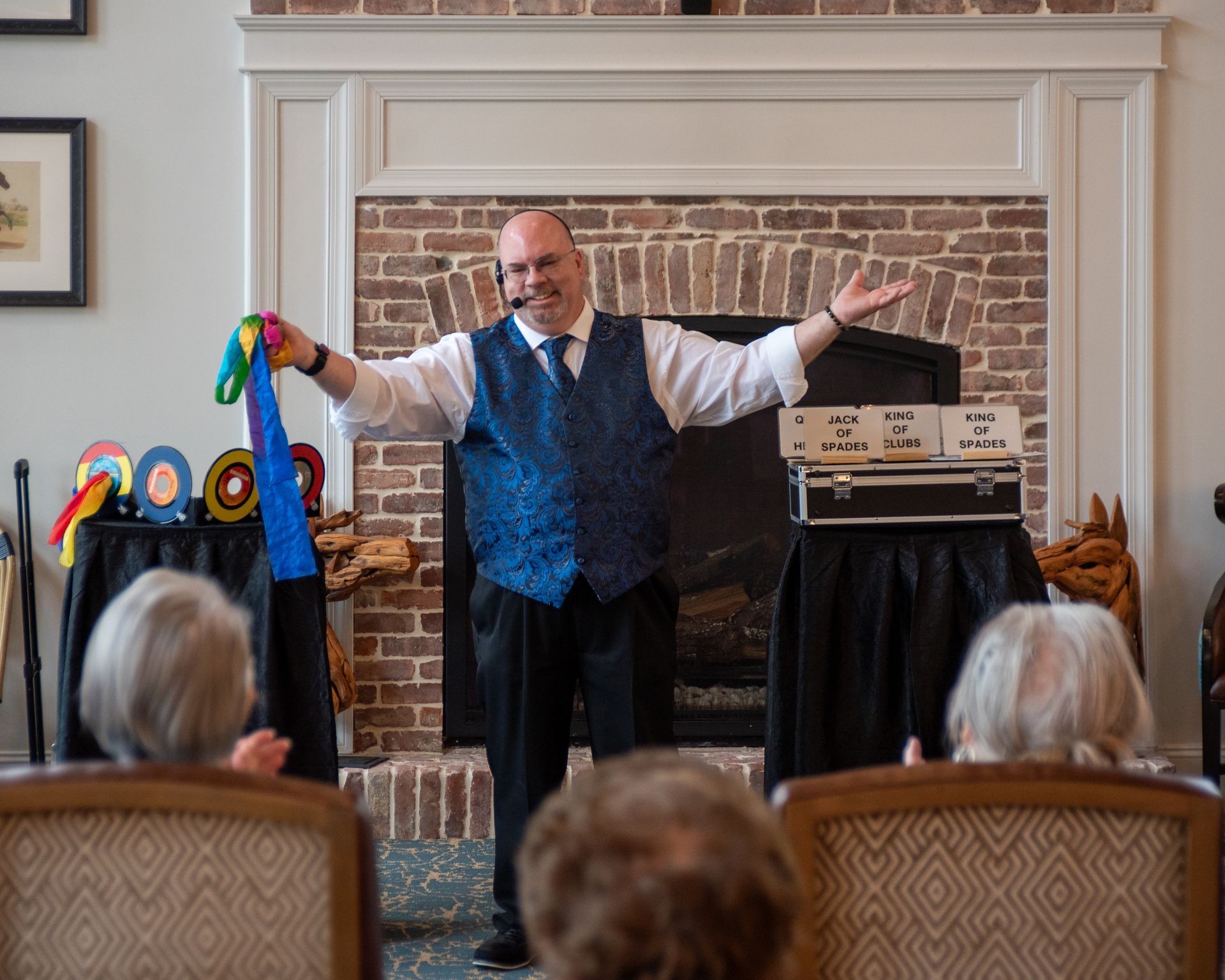 A man in a blue vest and tie is performing a trick