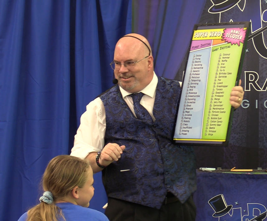 A man in a blue vest is pointing at something