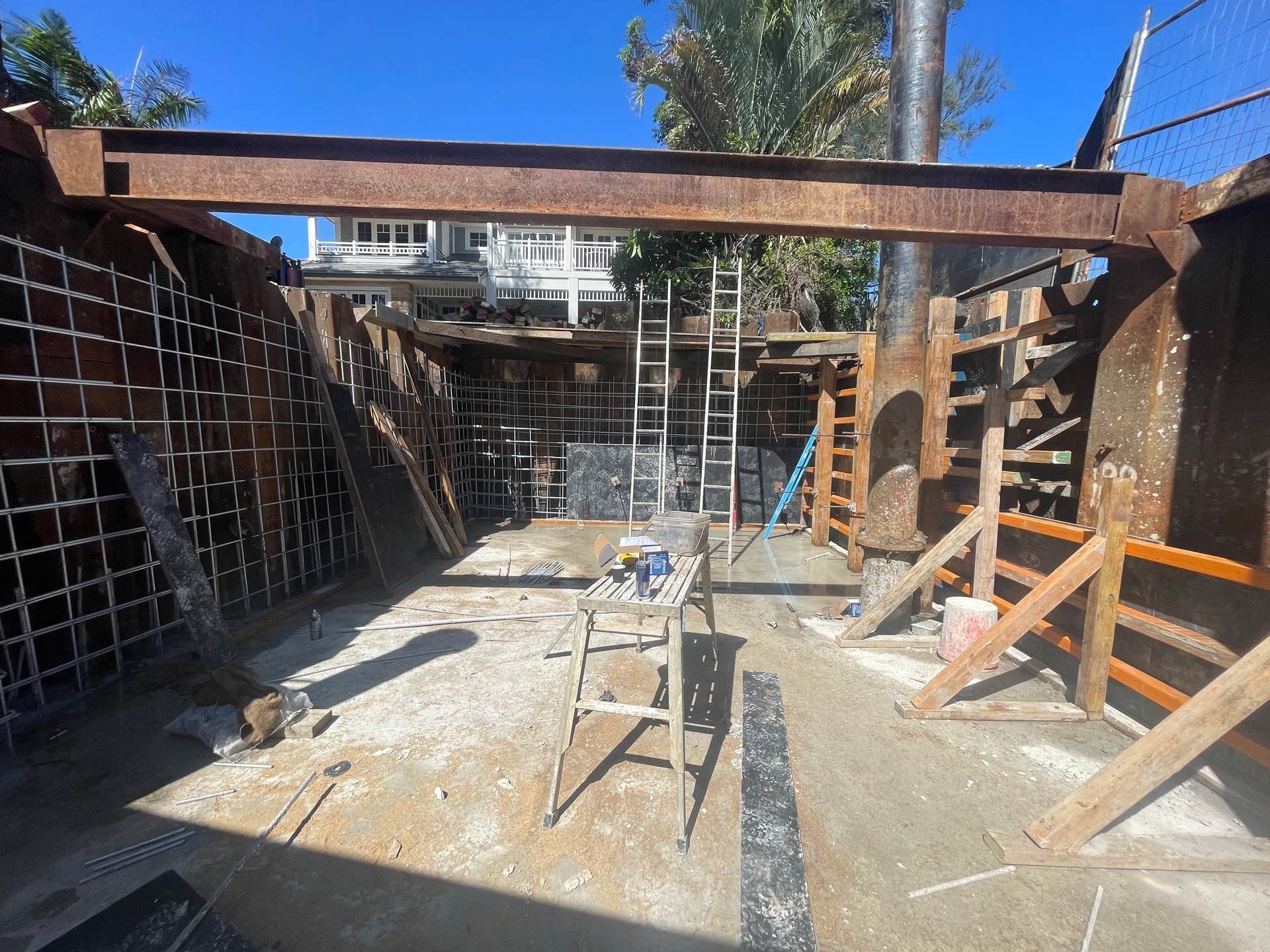 A construction site with a house in the background.