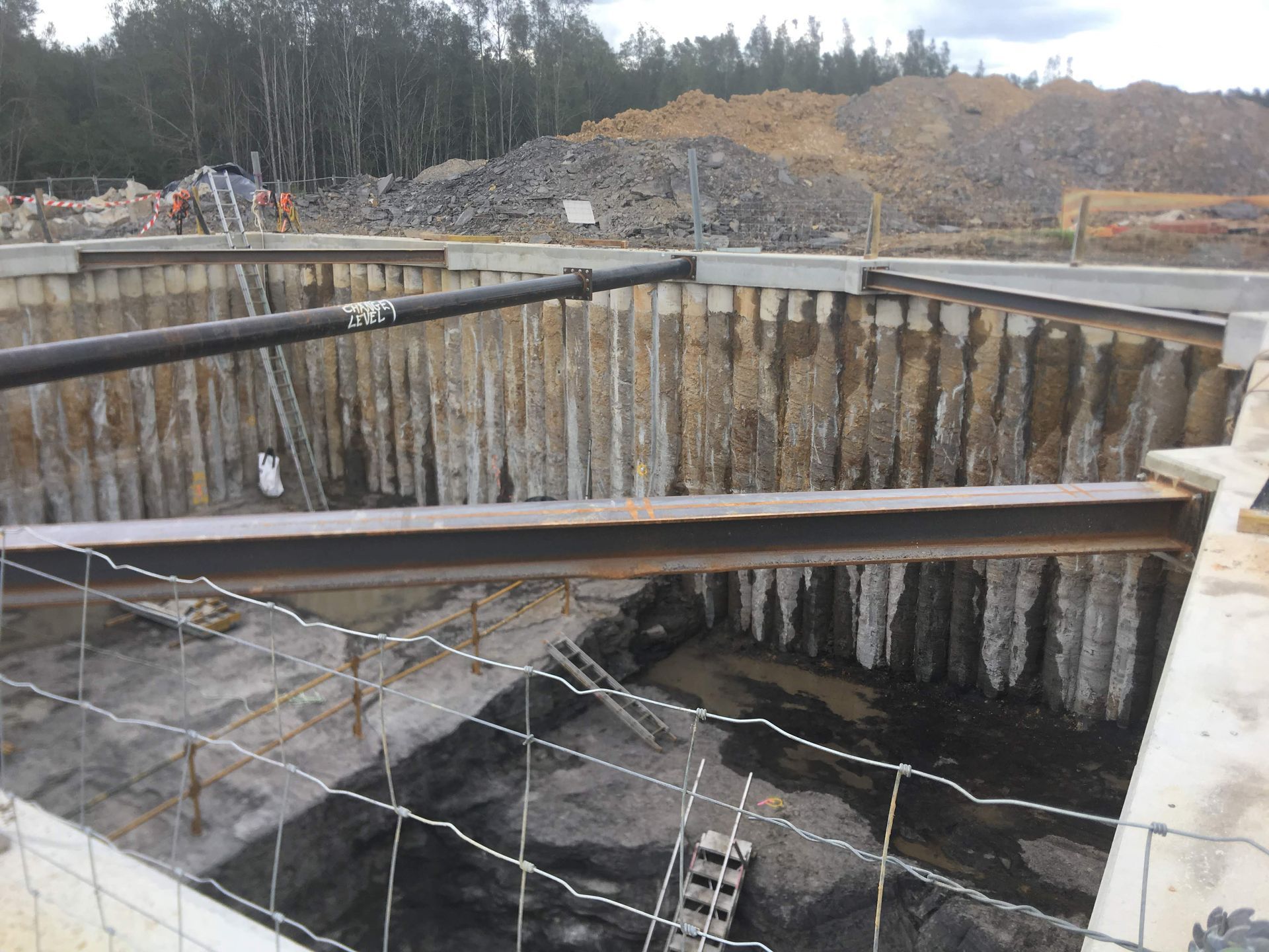 A large hole in the ground with a fence around it.