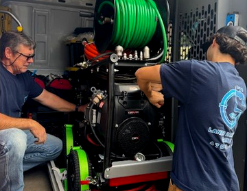 Wrench, brass fittings, and red valve on a wet, blue surface, likely representing plumbing or repair work.