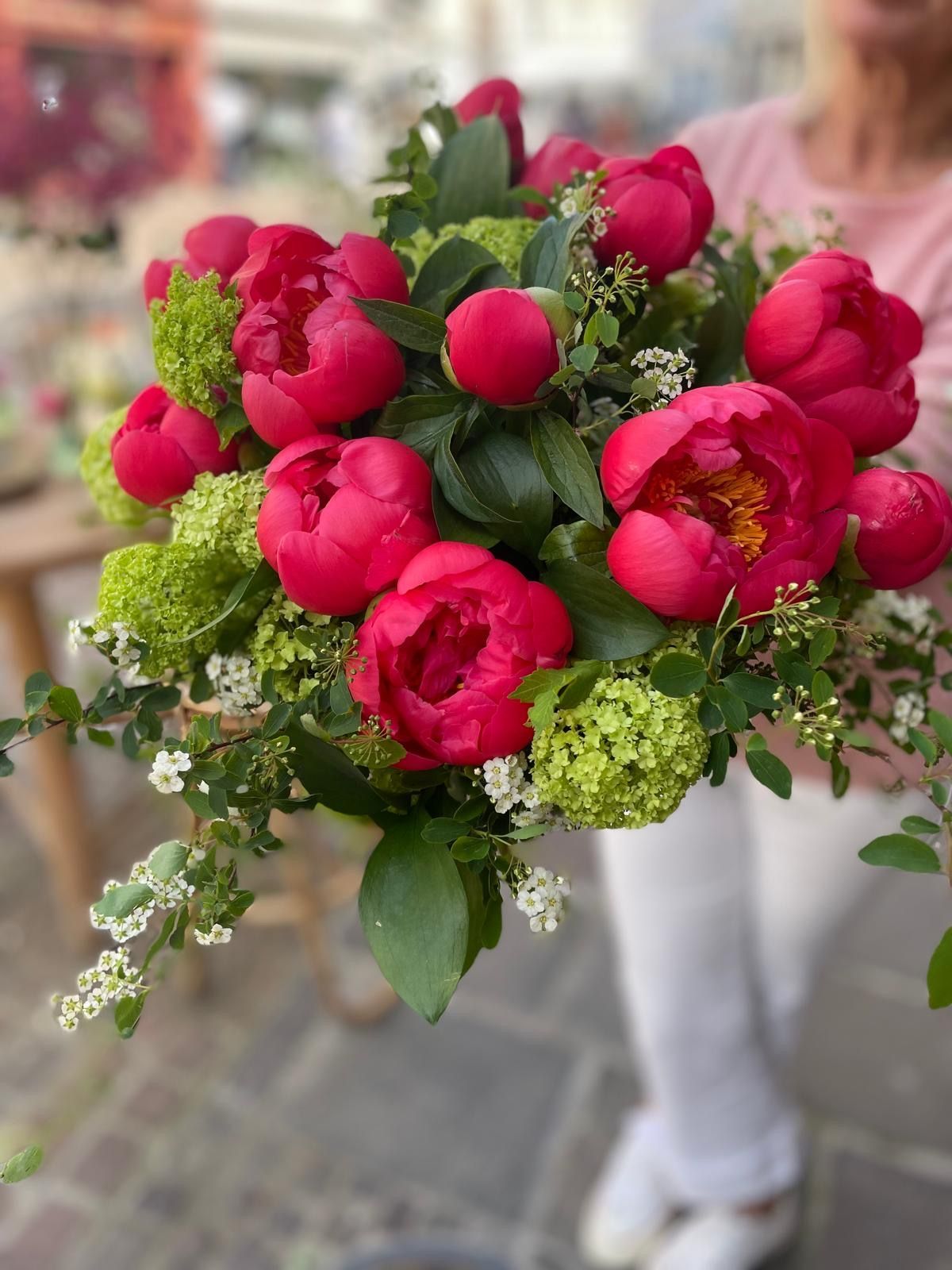 Une femme tient un bouquet de fleurs dans sa main.