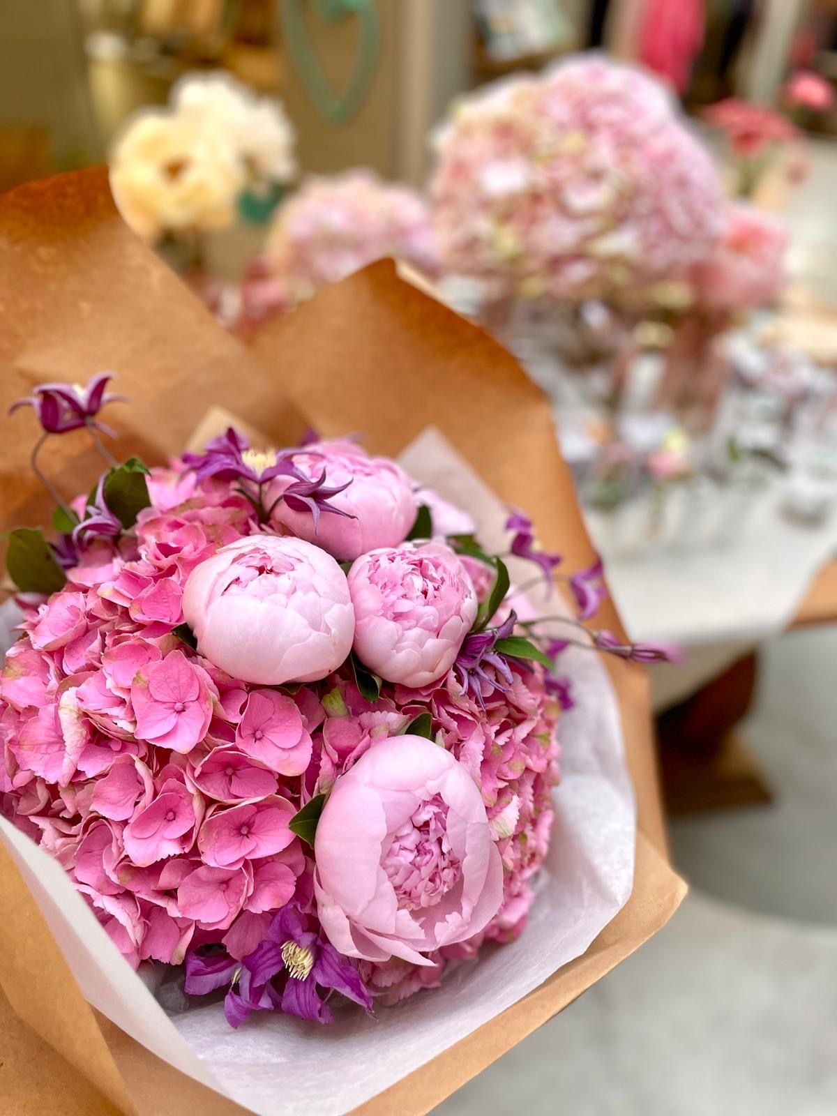 Une femme tient un bouquet de fleurs roses et jaunes.