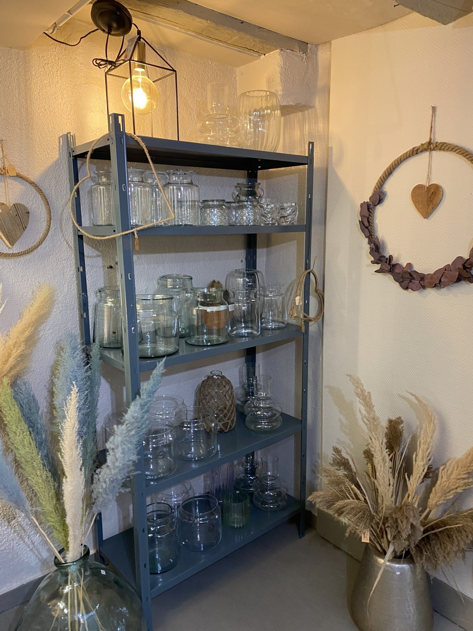 Une pièce avec une étagère remplie de vases et de fleurs.