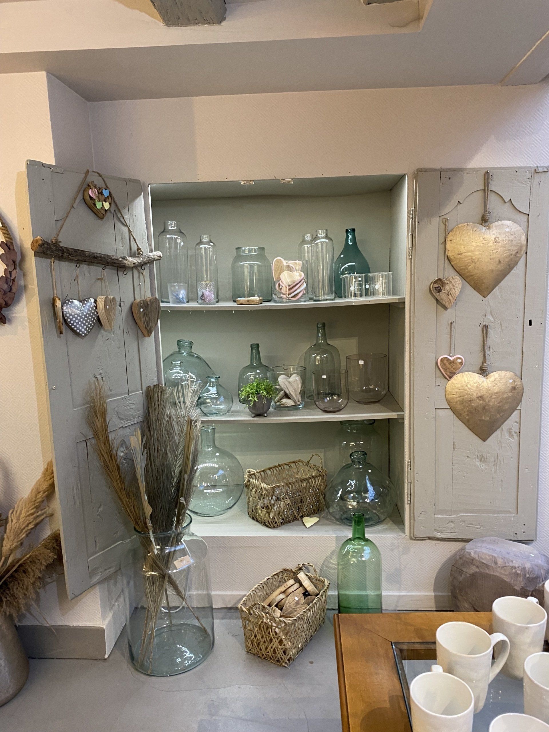 Une étagère remplie de vases et de tasses dans une pièce.