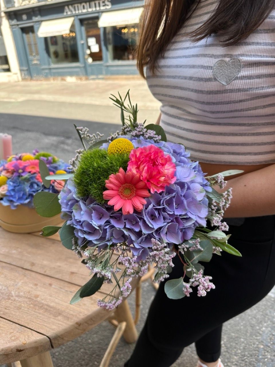 Une femme tient un bouquet de fleurs dans ses mains.