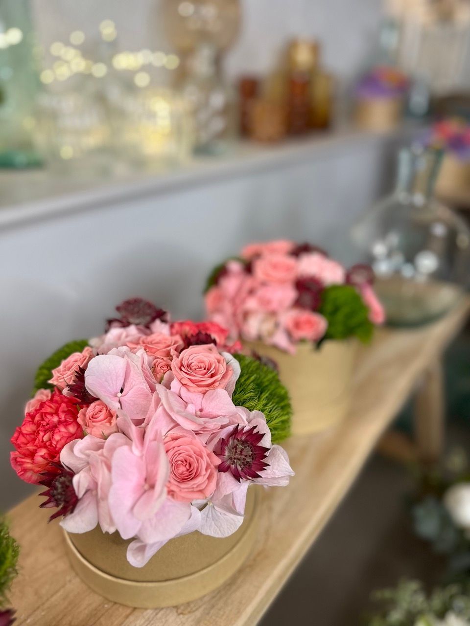 Une table en bois surmontée de vases remplis de fleurs roses.