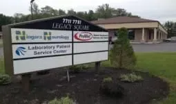 Outdoor sign for Legacy Health’s Laboratory Patient Service Center in front of a building.
