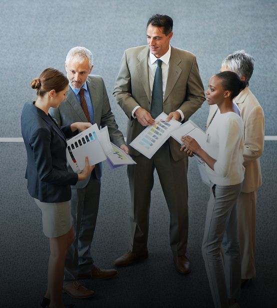 Businesspeople in a group, reviewing papers.