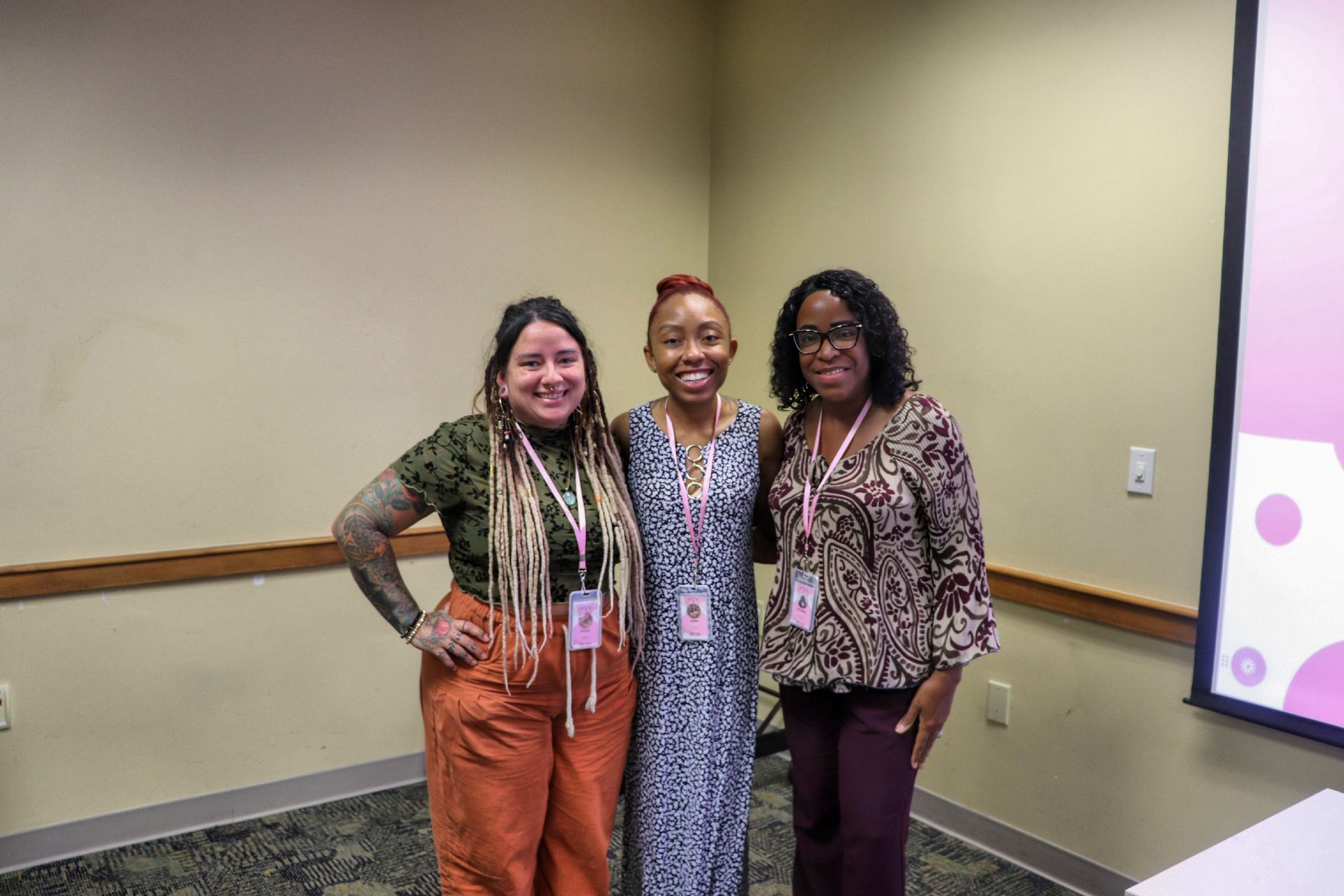 Three women are posing for a picture in a room.