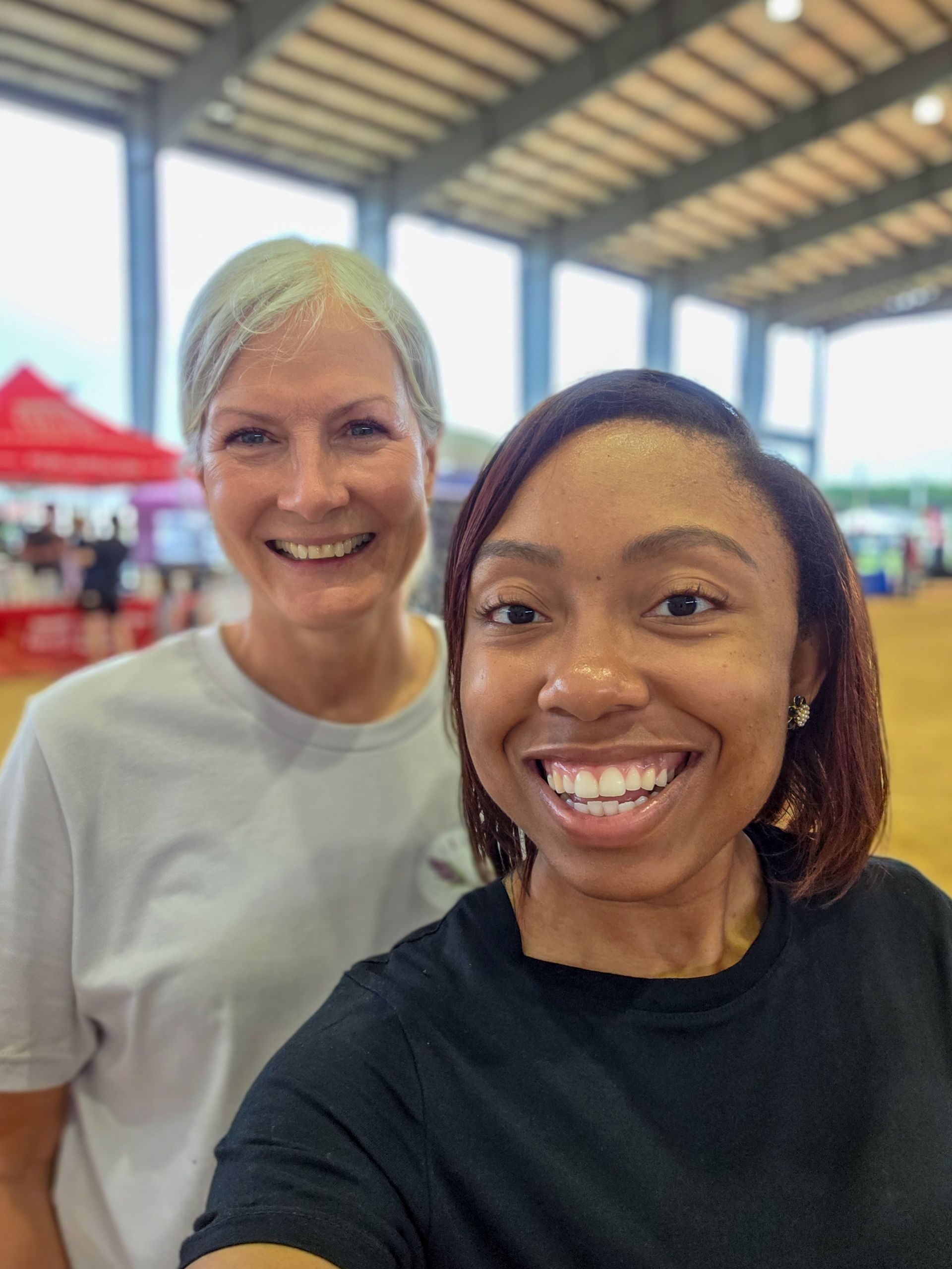 Two women are posing for a picture together and smiling.