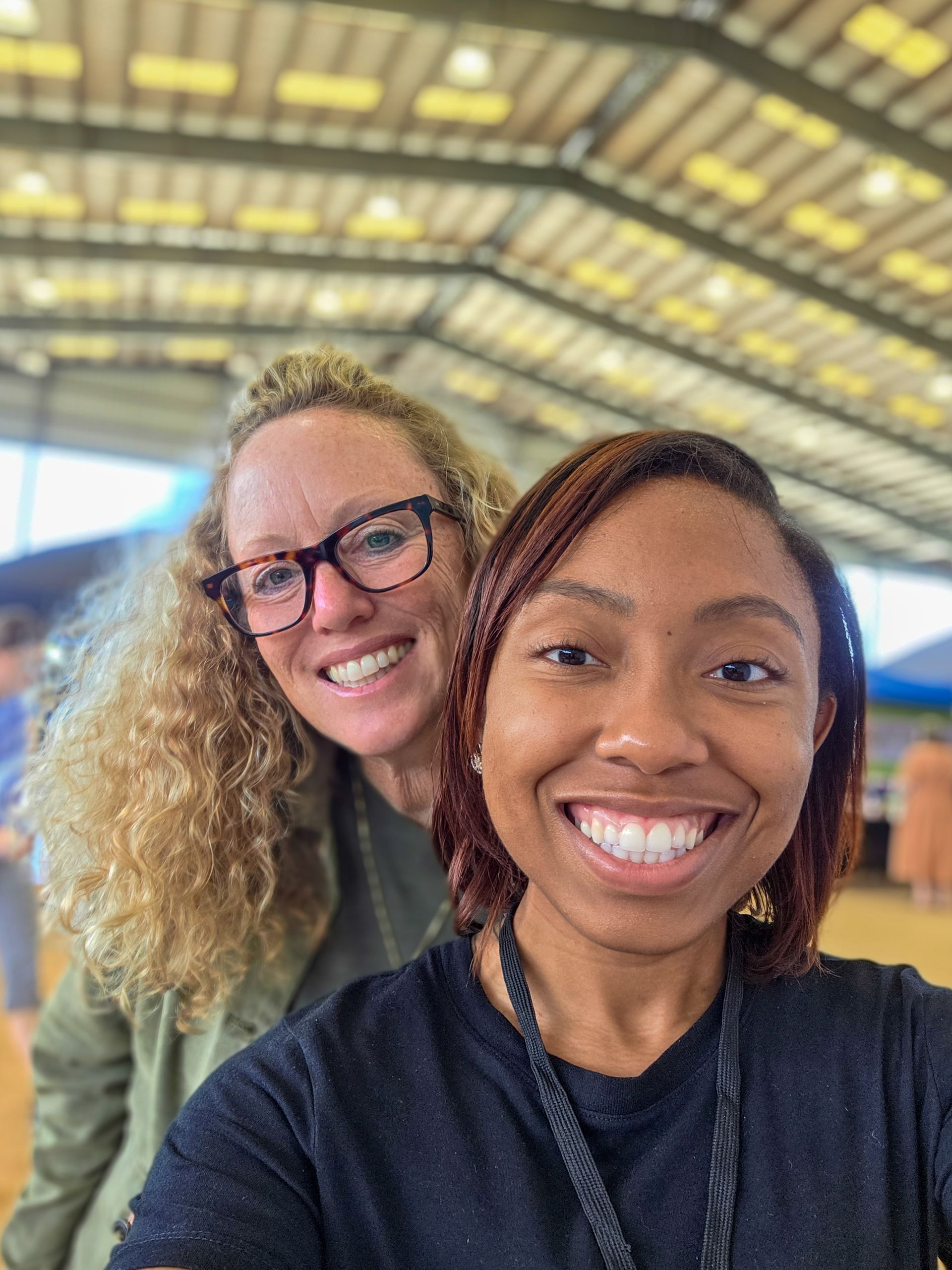 Two women are posing for a picture together and smiling.
