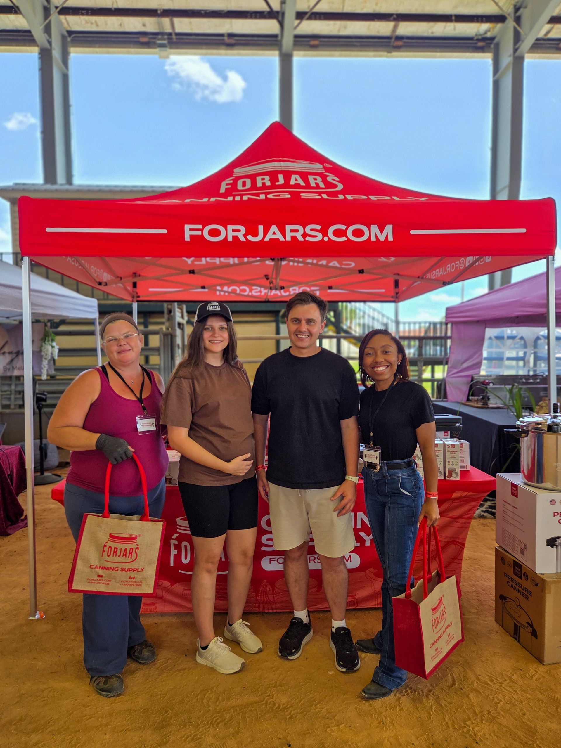 A group of people are standing under a red tent.