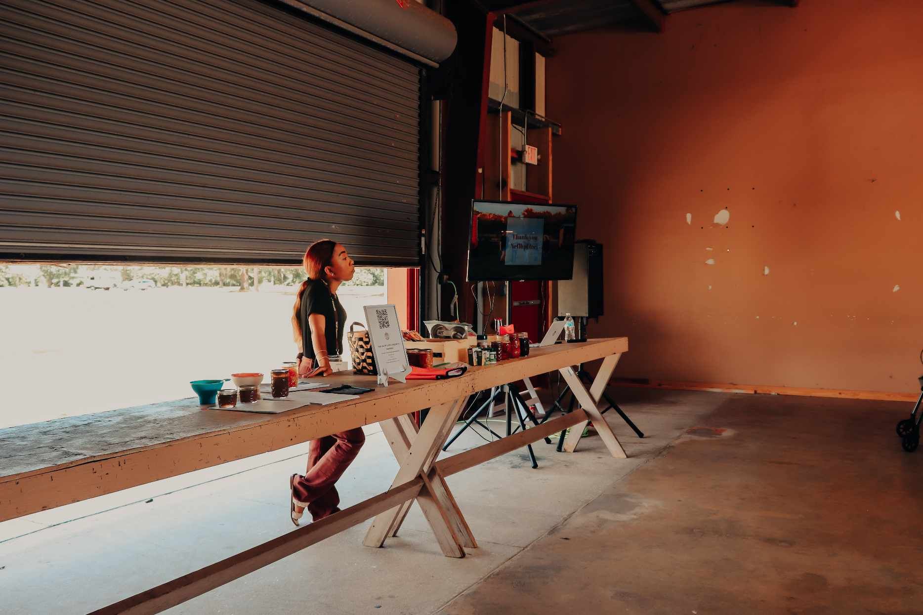 A man is standing in a garage looking out of a garage door.