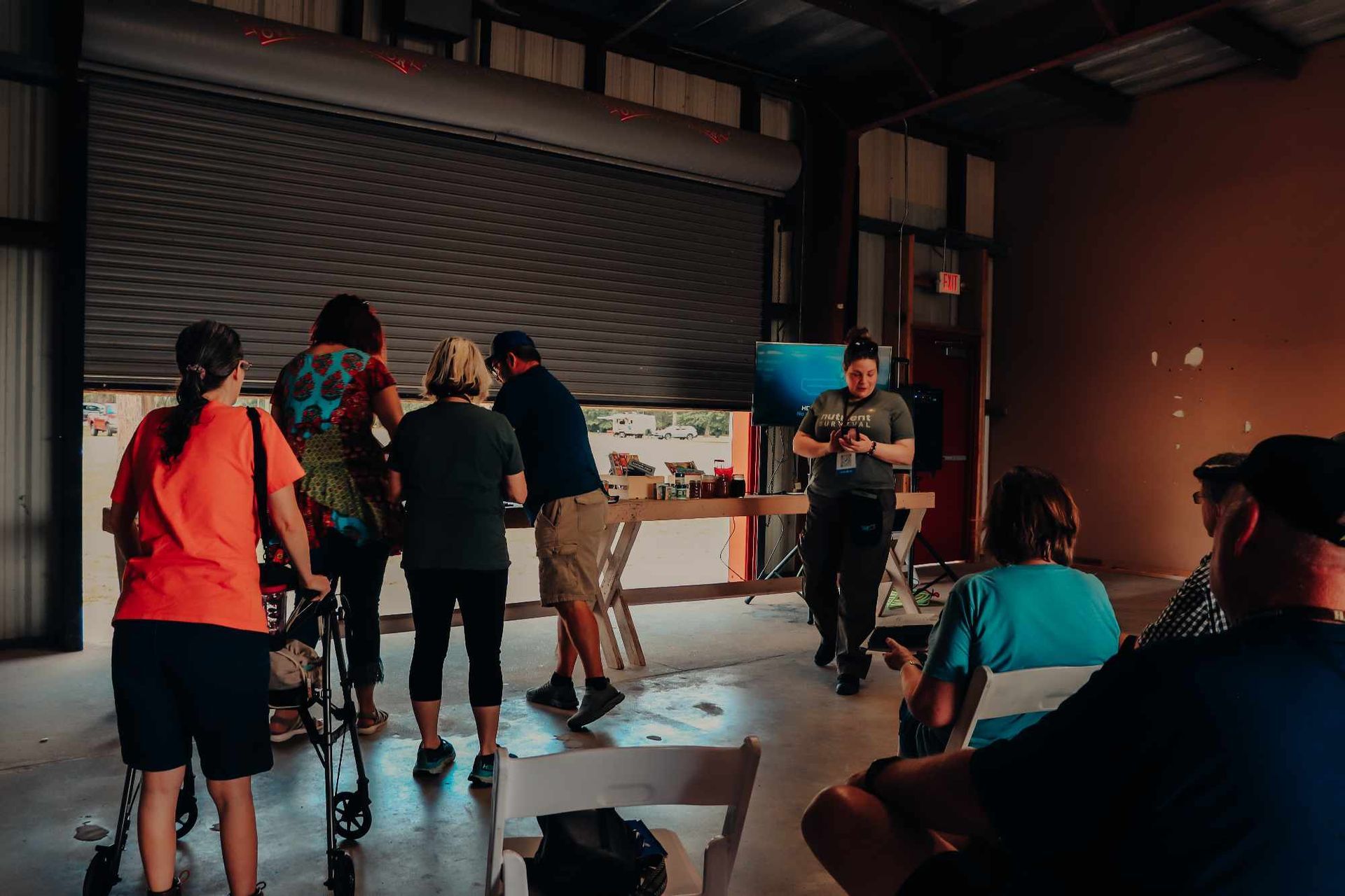 A group of people are standing around a table in a room.