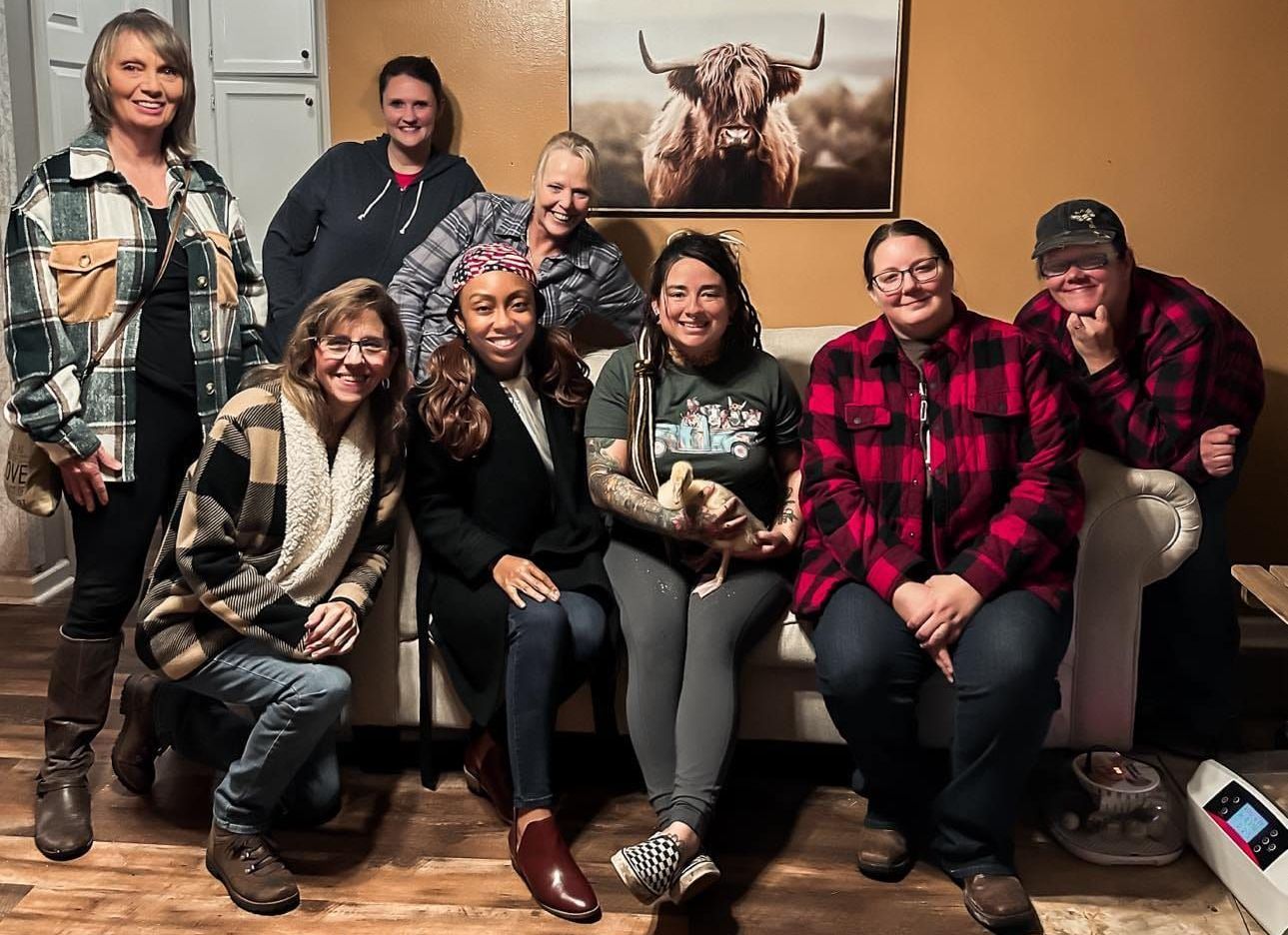 A group of people are posing for a picture while sitting on a couch.