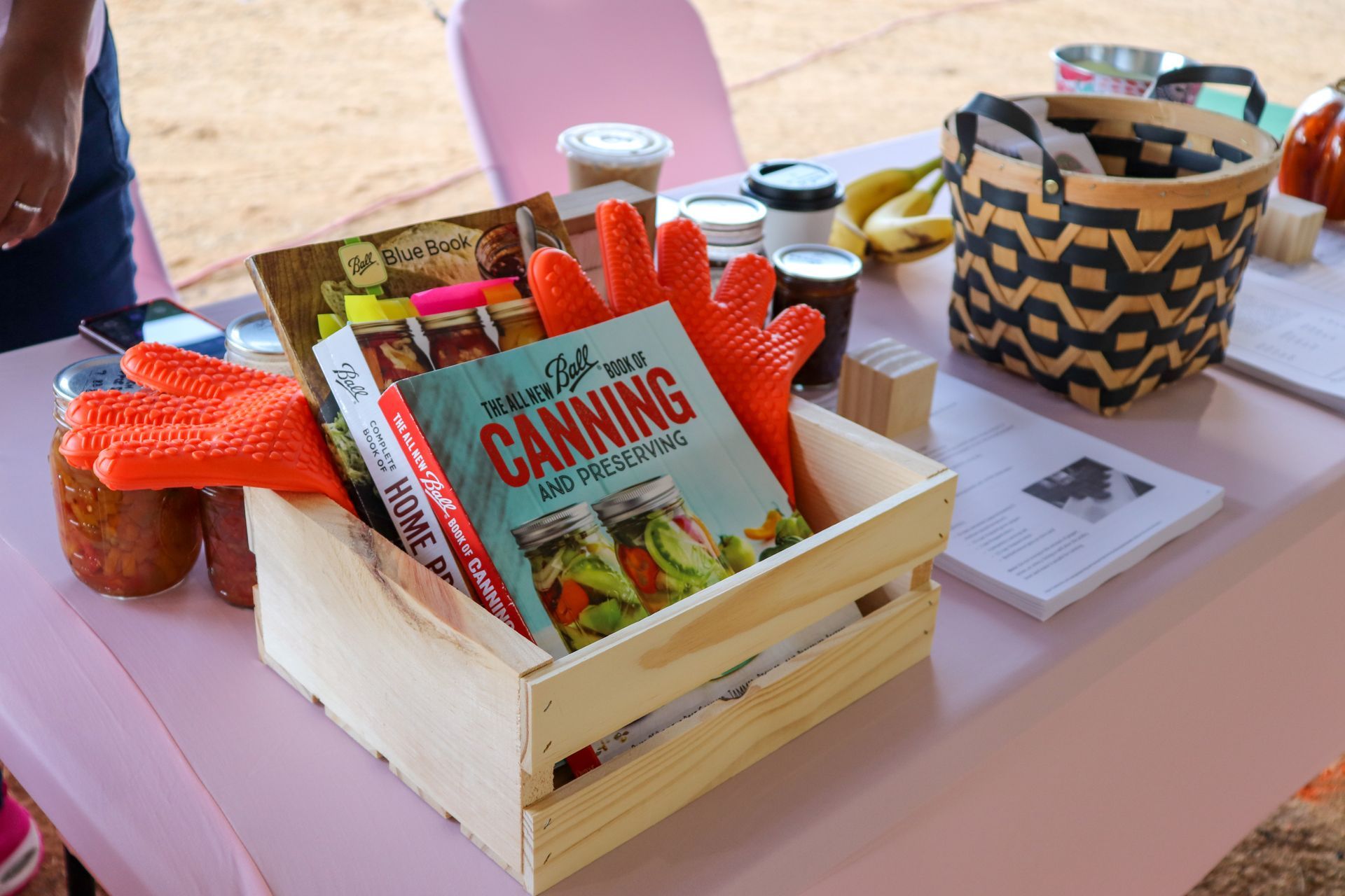 A wooden crate filled with canning supplies and a book.