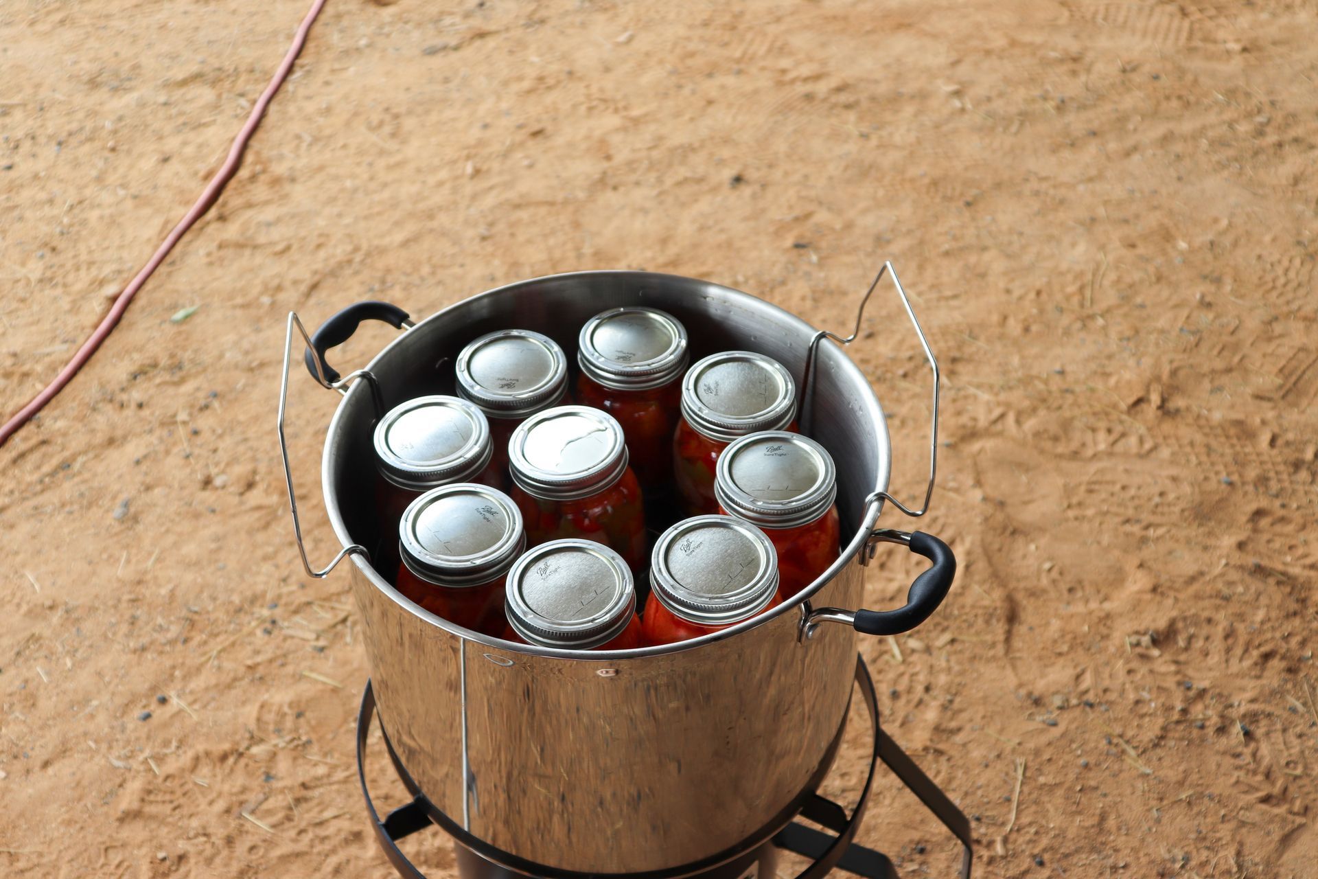 A pot filled with jars is sitting on the ground