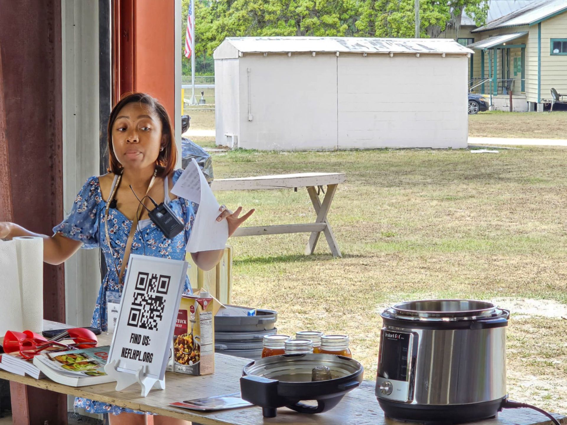 A woman is standing at a table with a sign that says qr code on it.