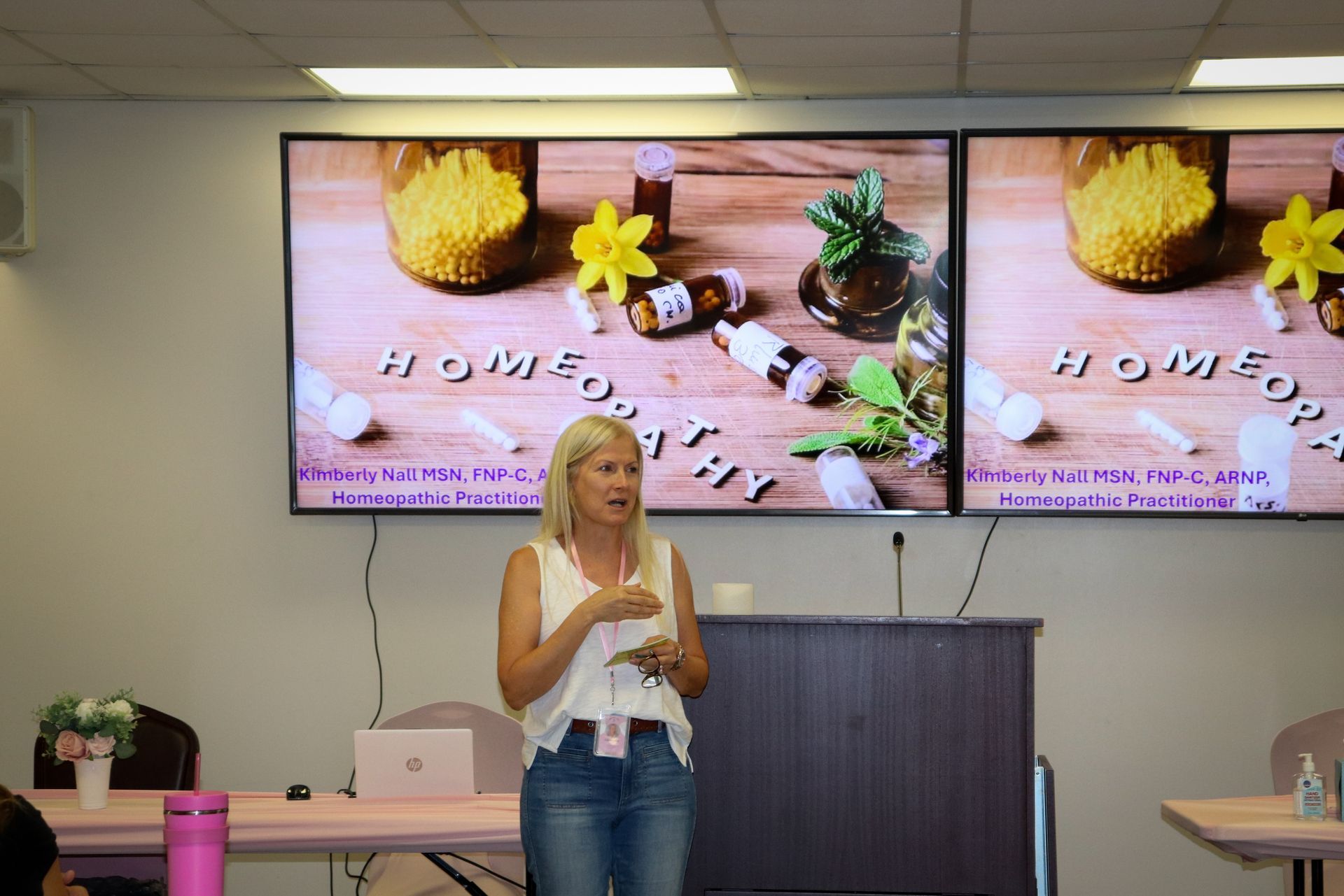 A woman is giving a presentation in front of a large screen.