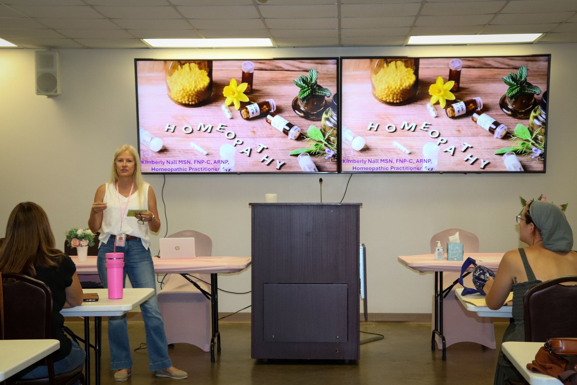 A woman is giving a presentation to a group of people in a classroom.