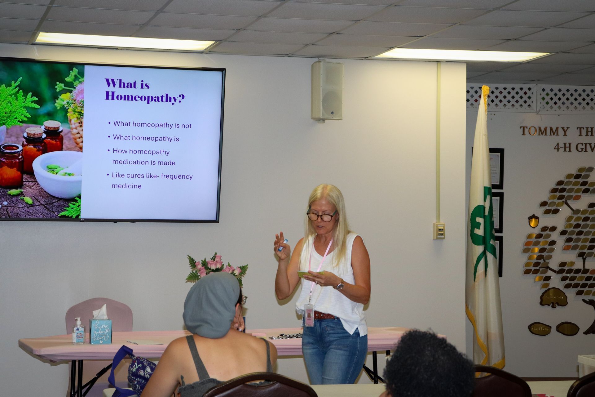 A woman is giving a presentation in front of a group of people.