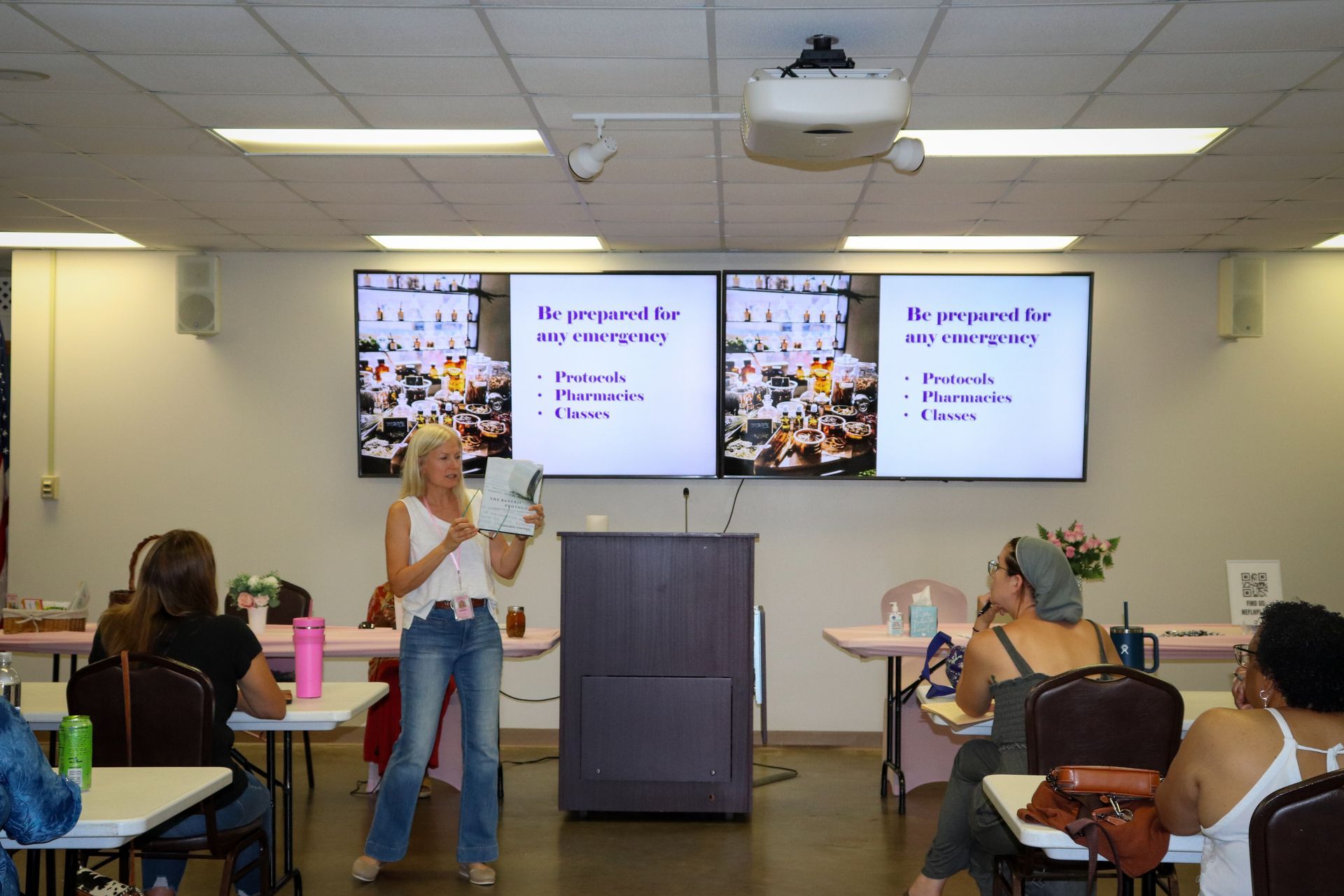 A woman is giving a presentation to a group of people in a room.