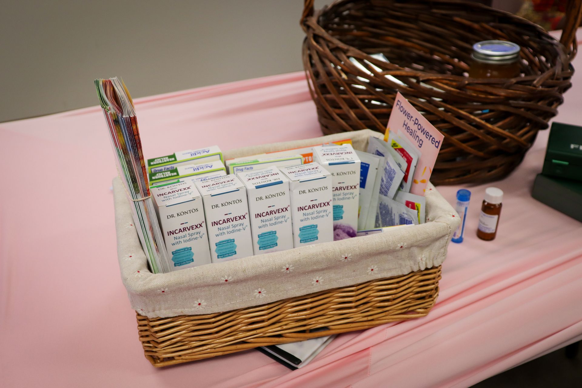 A wicker basket filled with boxes of medicine on a table.