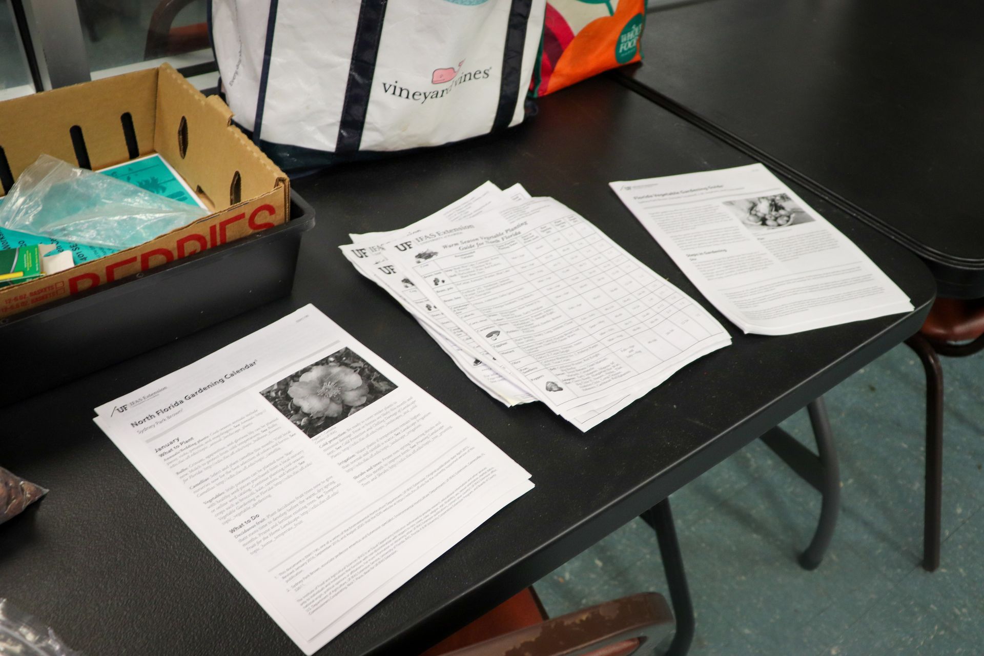 A table with papers and a box that says becodes on it