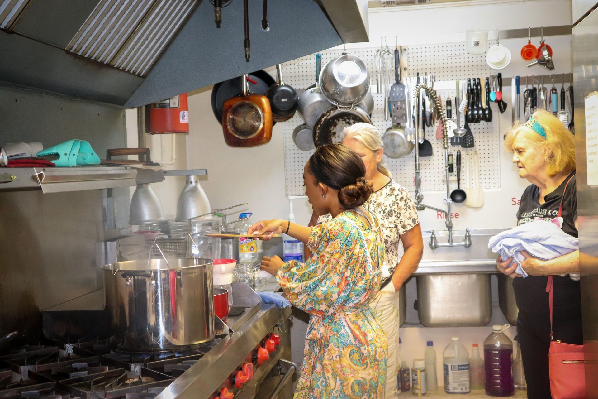 A group of people are standing in a kitchen preparing food.