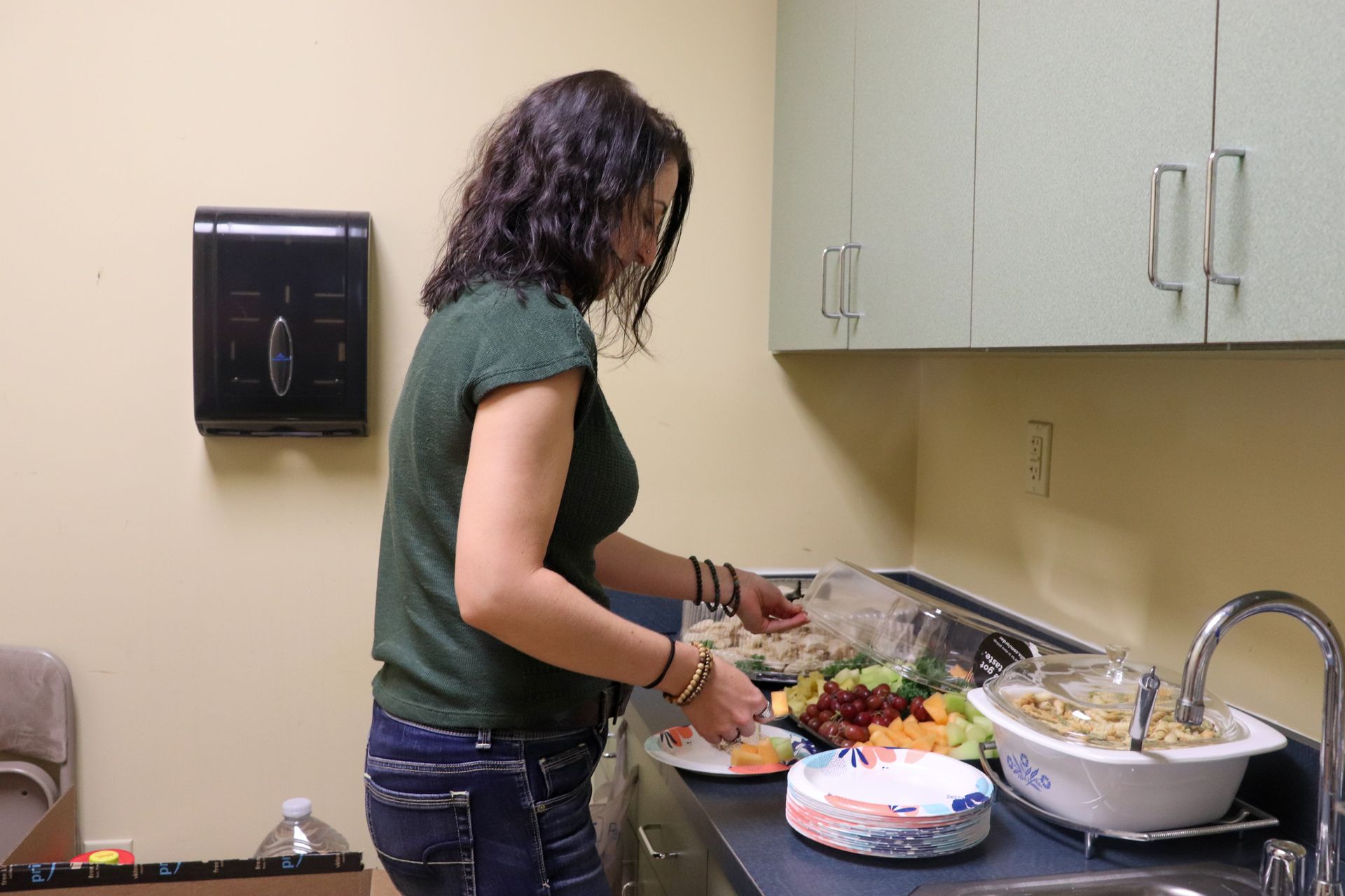 A woman is preparing food on a counter in a kitchen.