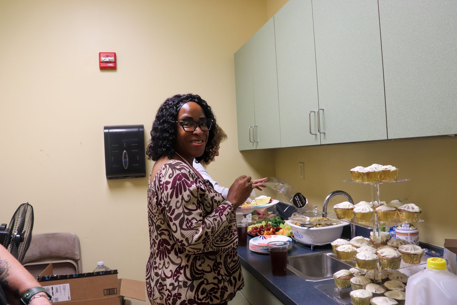A woman is standing in a kitchen preparing food.