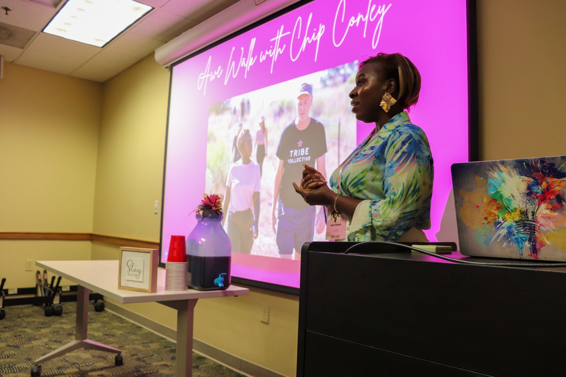 A woman is giving a presentation in front of a large screen.